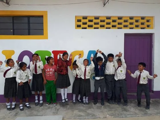 Escolares celebrando frente a su nueva biblioteca